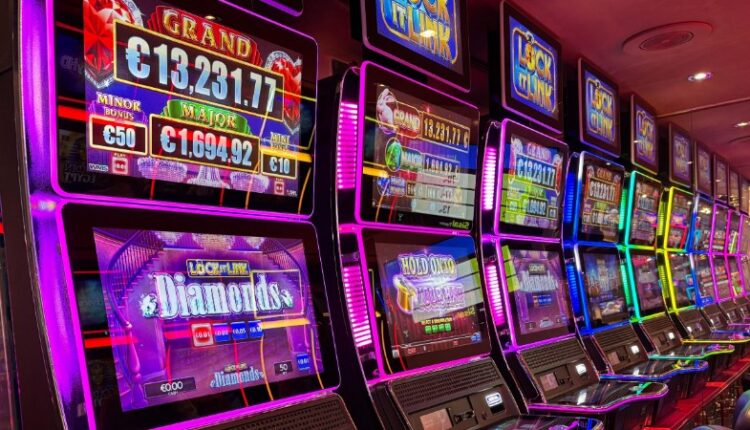 Colorful slot machines lined up in a casino with neon lights and jackpot displays., tags: 100 % rtp - pexel
