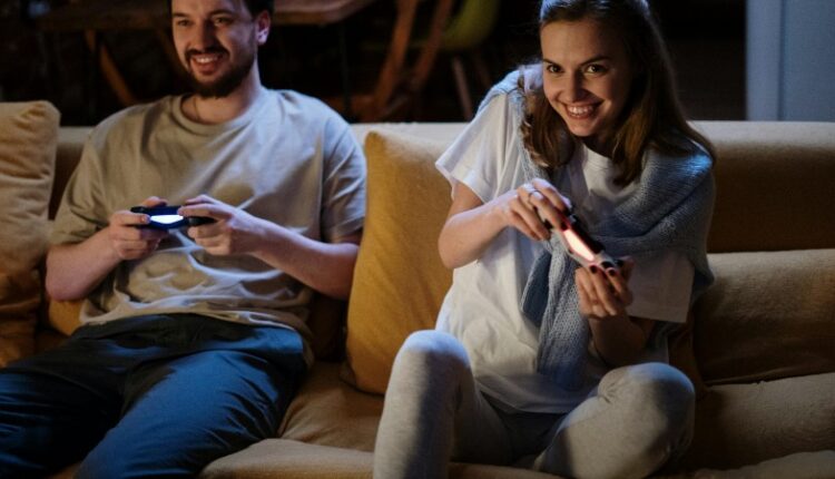 A happy couple plays video games on the sofa during a cozy evening at home., tags: bessere erlebnisse für alle - pexel