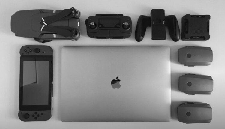 A black and white flat lay of various modern tech gadgets including a laptop, drone, and gaming device., tags: ist ein mac - pexel