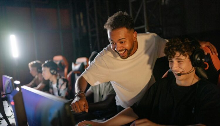 Gamers in a high-energy tournament setting enjoy competitive play with enthusiasm and teamwork., tags: die - pexel