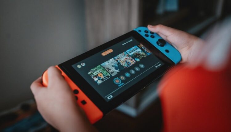 person holding black and orange nintendo switch - Nintendo Switch!, tags: verlagert auf unterstützt die - unsplash