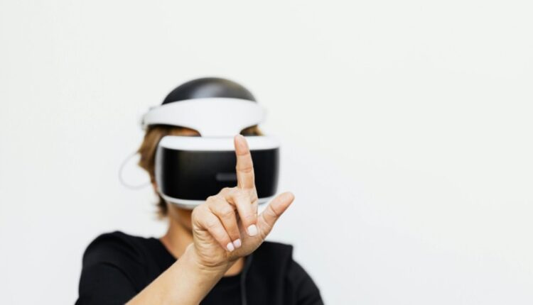 Woman interacting with virtual reality technology in a modern setting, wearing a VR headset on a white background., tags: online-casinos - pexel