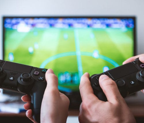 Zwei Personen spielen FIFA auf der PS4